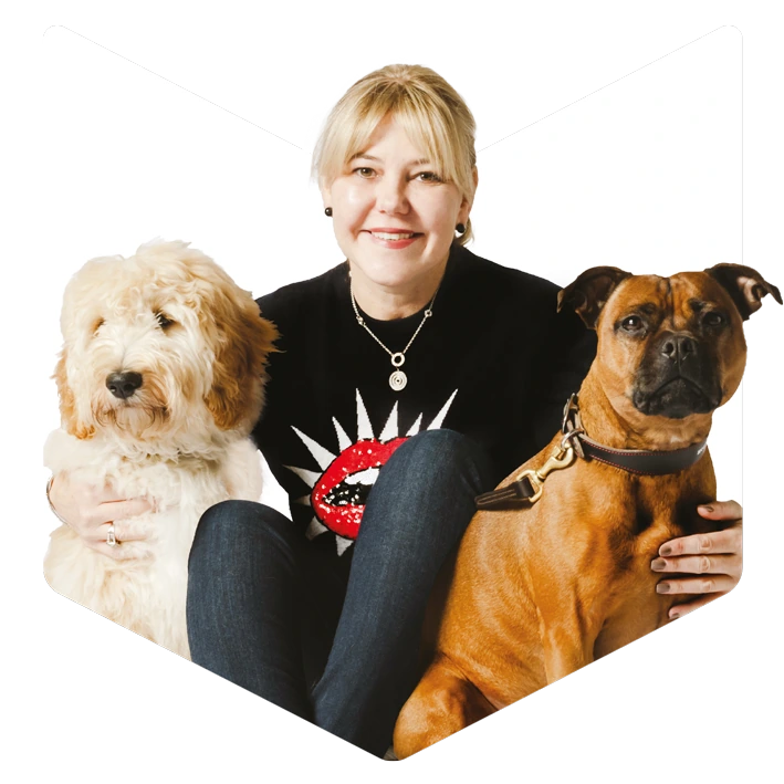 Houndztooth founder Rachael Tricarico with her two dogs, framed in the Houndztooth shield