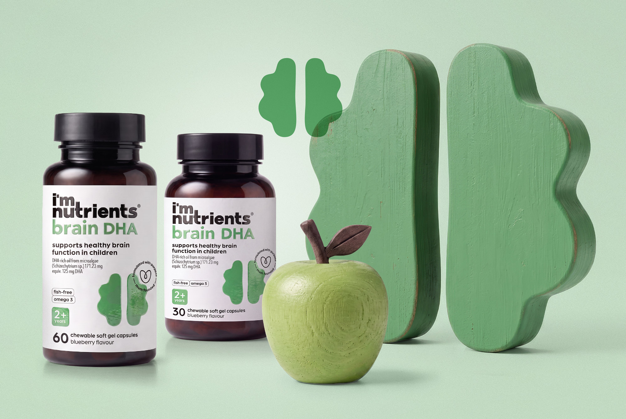 I'm Nutrients Brain DHA bottles with green brain forms and an apple